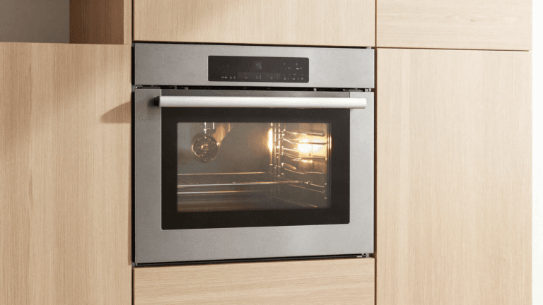 Forno elétrico de embutir em inox instalado em marcenaria de madeira clara